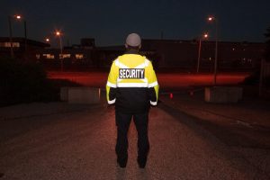 Security guard in yellow and black jacket on street