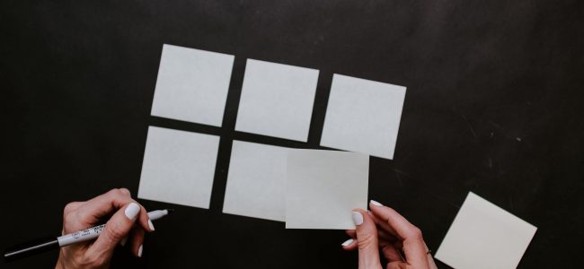 Person holding white post-it notes and organizing