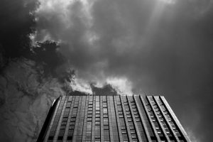 High rise office building reaches up toward a cloudy sky