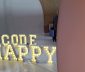 A set of illuminated letters spelling out Code Happy